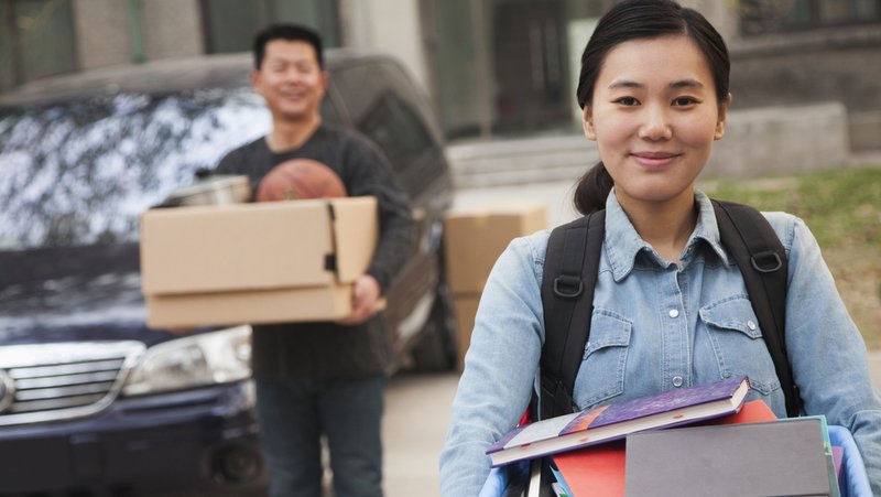 Student being dropped off at college by her father.